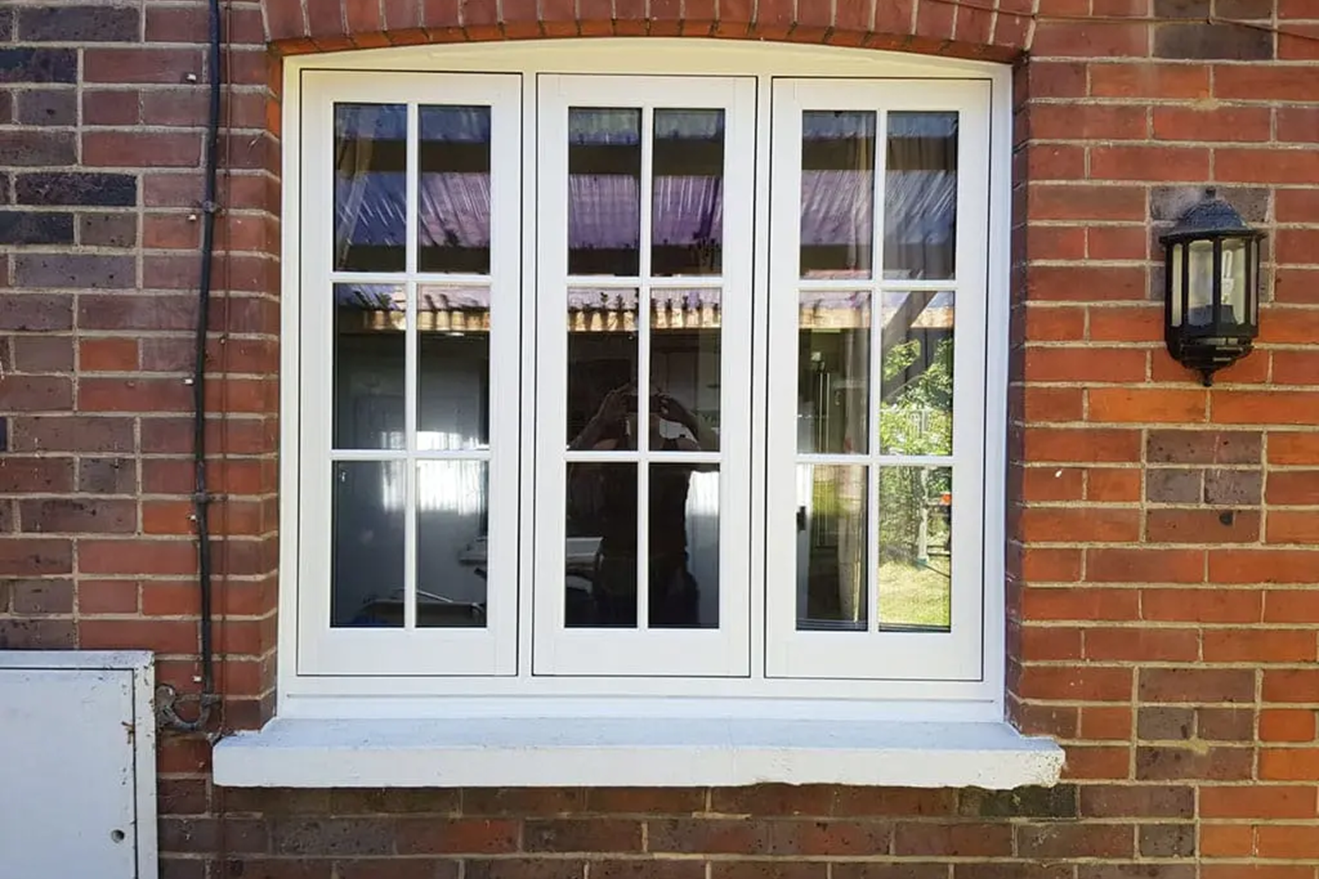 White flush timber casement window on red brick home