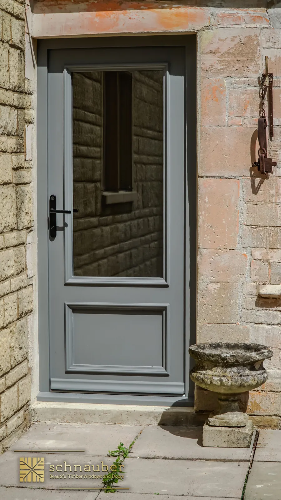 Grey heritage timber glazed door in a stone wall