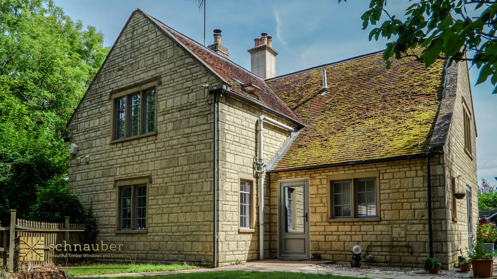 Stone cottage with grey timber windows after installation